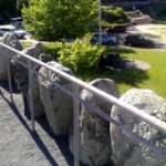 Crest of The Rockery; stones arranged to honor the fallen; Oakes Ames Memorial Hall in background